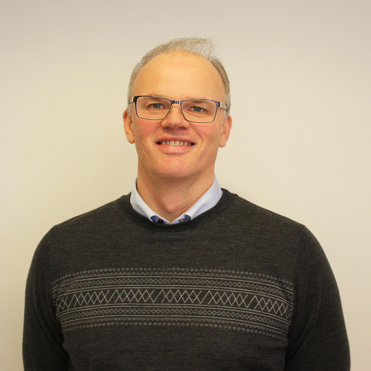 Mann med mørk genser og briller